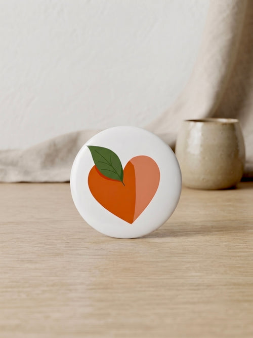 Chapa corazón naranja Terreta – vista en entorno natural sobre madera